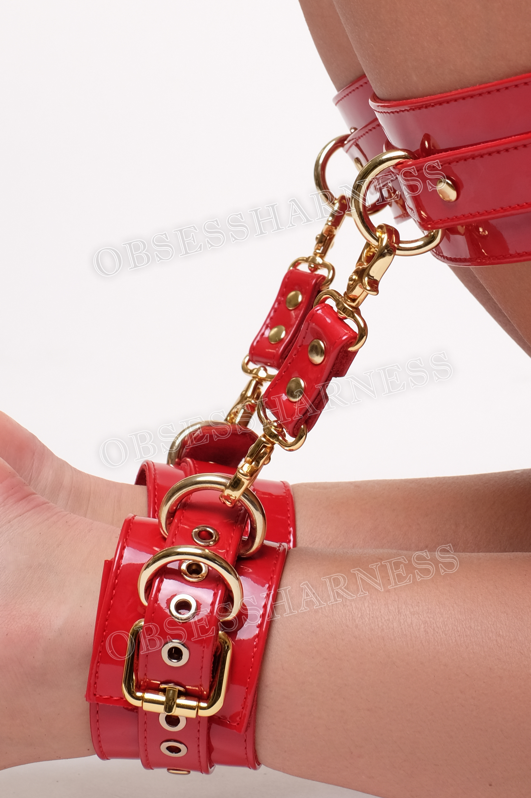 Leather bdsm thigh and ankle cuffs patent leather red for fastening a submissive from behind in a pig position the wrists and hips, equipped with rings 
