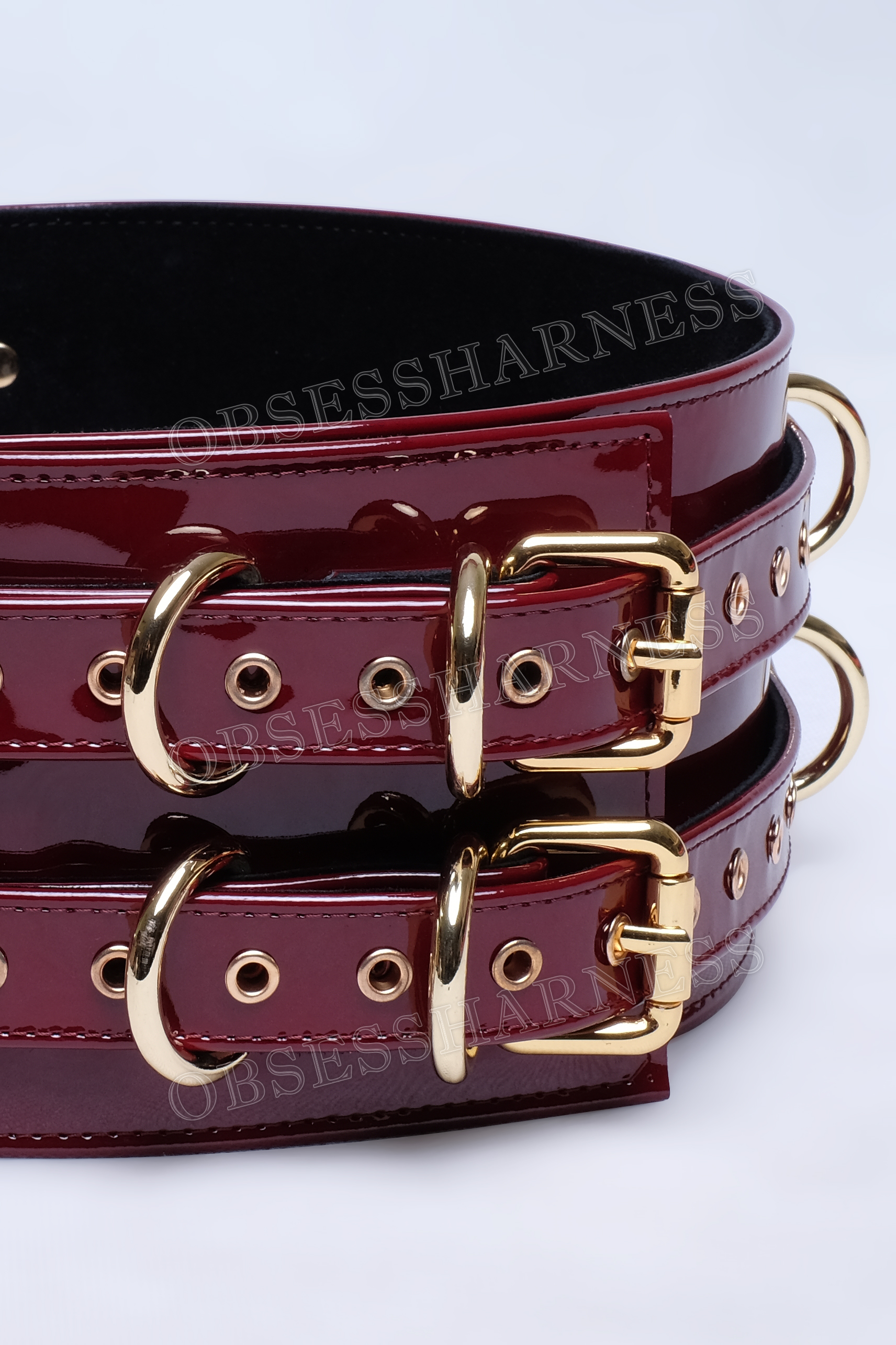 Luxury bondage Belt harness for BDSM made of patent wine leather with an internal suede layer and two metal fasteners on the belt, a belt with D-rings on the sides and back for attaching restraints to the slave for role-playing games